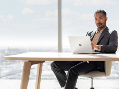 A man sitting at a desk using a laptop.