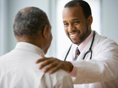 Person in a white coat and another person interacting in a healthcare setting.