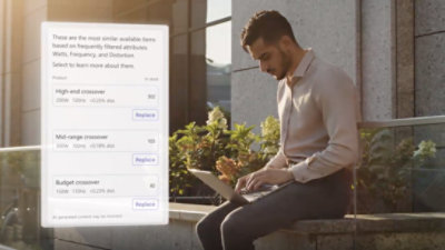A person sitting on a stone ledge using a computer