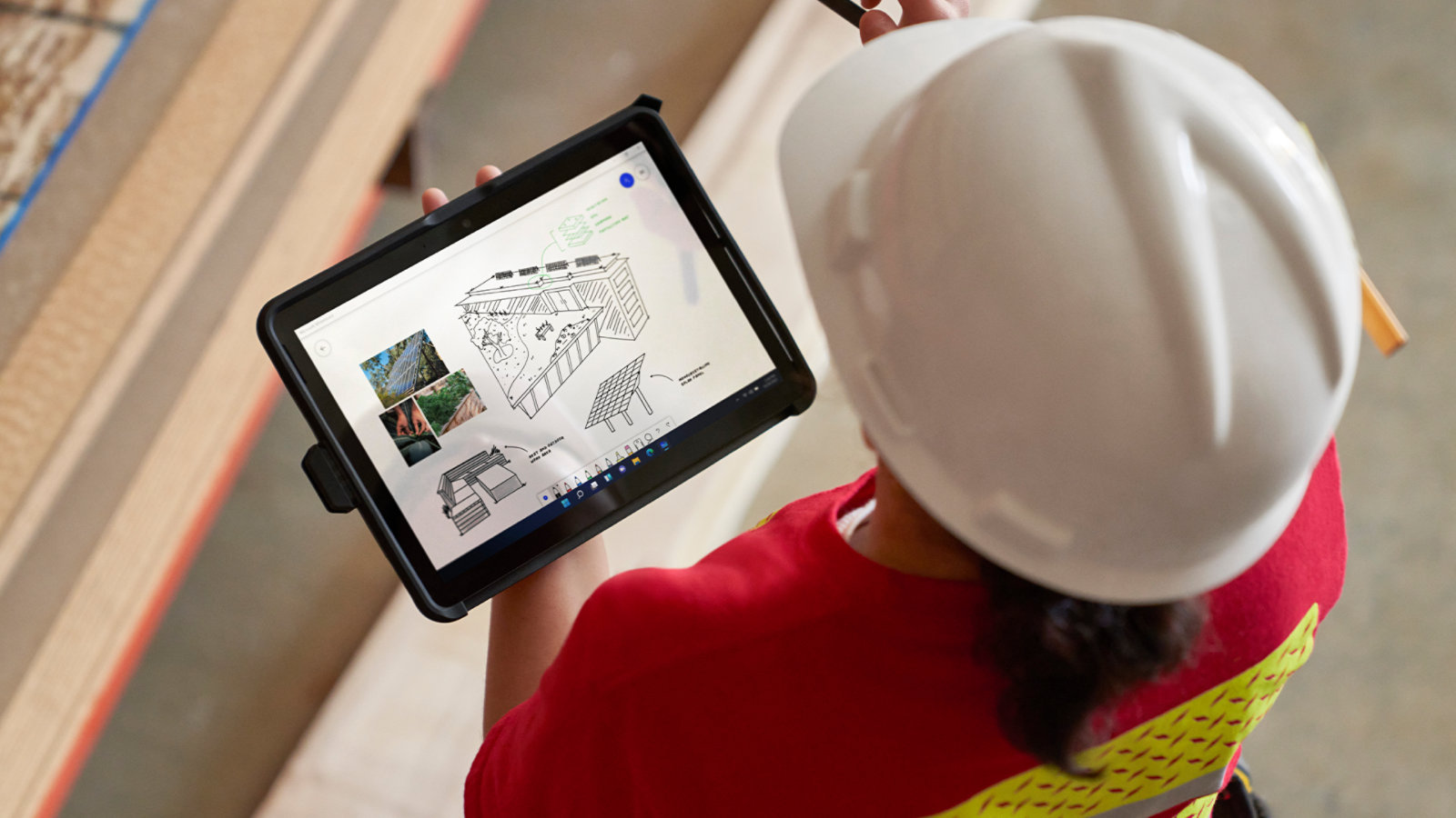 En person med beskyttelseshjelm bruger en Surface Go 4 til erhverv på arbejdet, hvilket fremhæver enhedens mobile egenskaber.