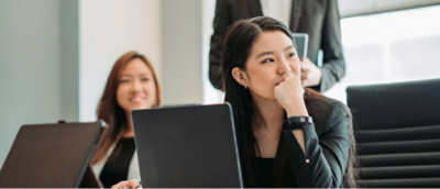 Two women looking at something with laptops infront