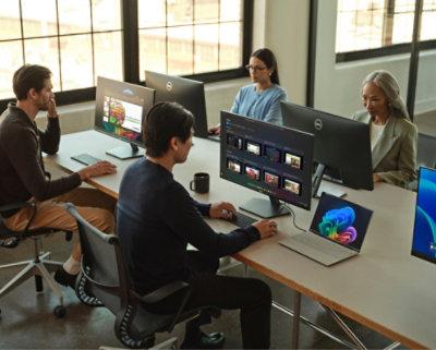 A group of people sitting at a table with computers.