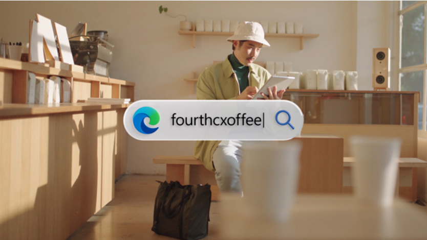 A person holding a tablet looking down with a coffee cup in their hand. In the center of the image is a search bar with the Edge icon on the left and the search bar text reads fourthcxoffee
