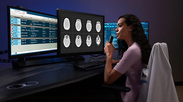 Una persona con varios monitores, mirando los datos en pantalla y mirando.