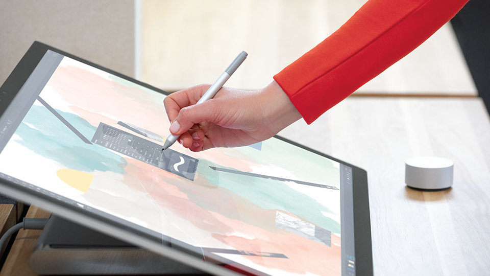 A person uses Surface Pen to write on the display of Surface Studio 2.