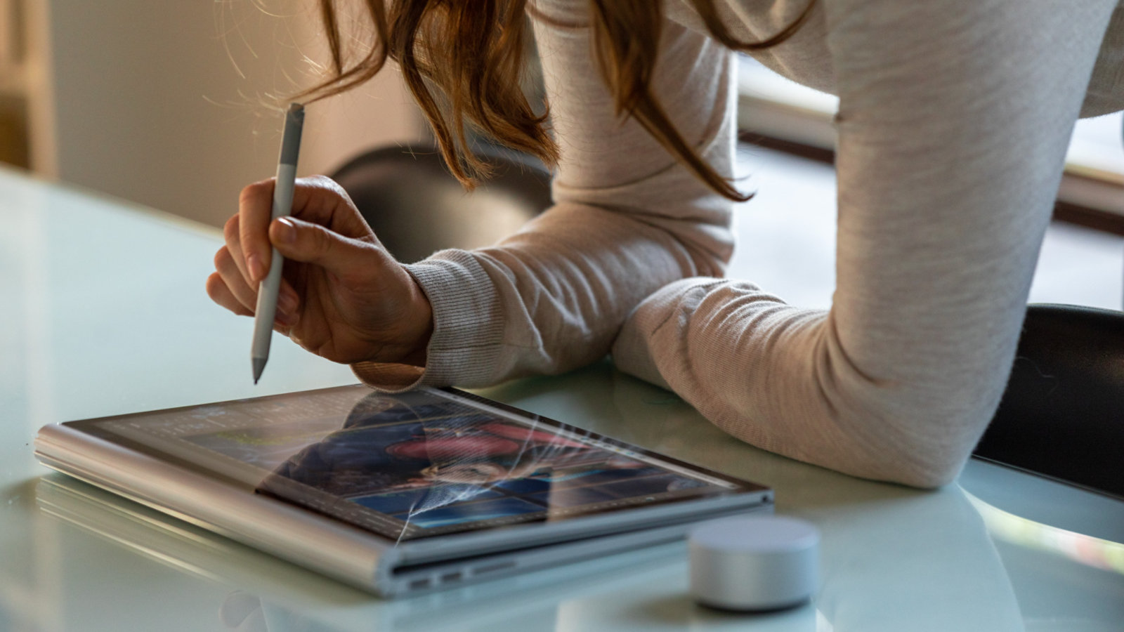 En kvinne bruker Surface Book 3 som et nettbrett med Surface-penn og Surface Dial