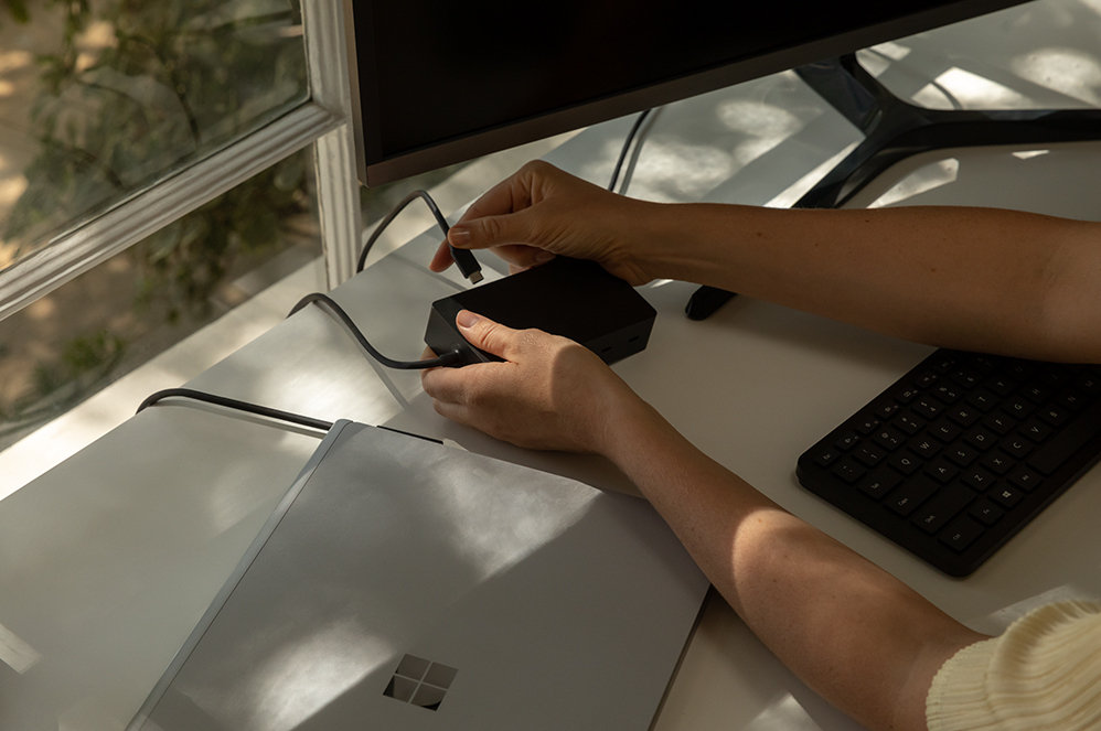 Une personne connectant une Surface Dock 2 pour les entreprises à un appareil Surface.