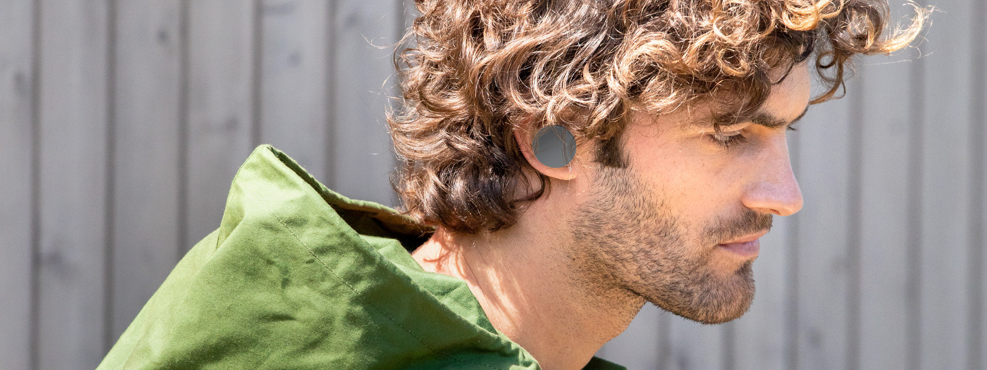Mężczyzna z założonymi słuchawkami dousznymi Surface Earbuds z nakładkami w idealnym dla niego rozmiarze.