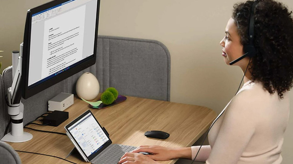 Eine Person verbindet das Surface Go 4 mit dem Surface Dock 2, um einen 4k-Monitor hinzuzufügen und ein vollständiges Desktop-PC-Erlebnis zu haben