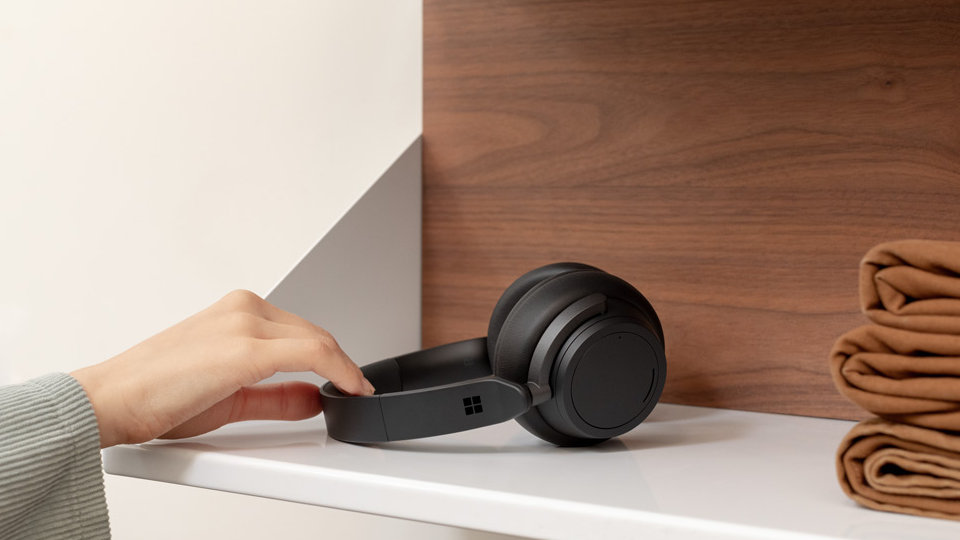A person picks up Surface Headphones 2 off of a shelf