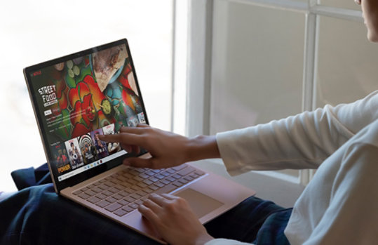 Person typing and touching the screen on Surface Laptop 3.