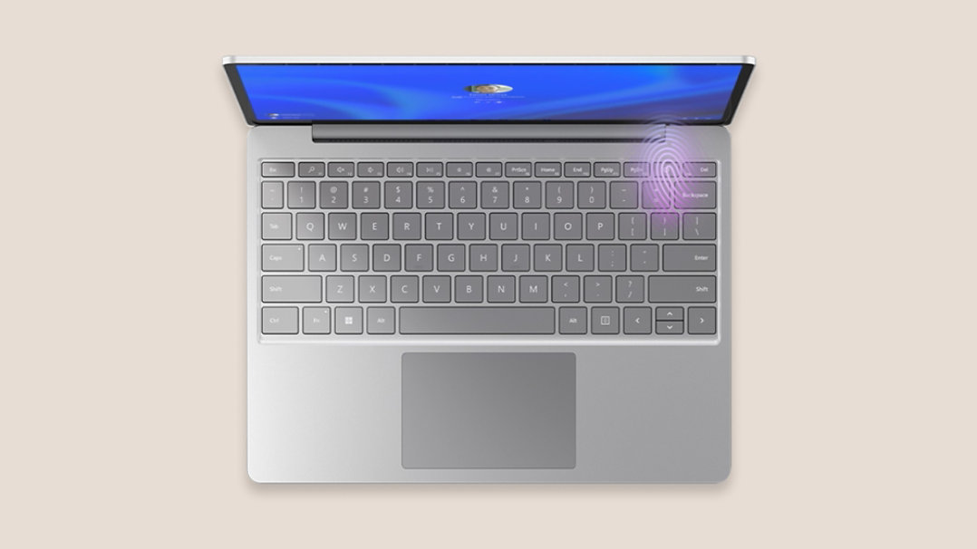 Platin Surface Laptop Go 3 set oppefra med fingeraftrykslæseren oplyst i tastaturets øverste højre hjørne.