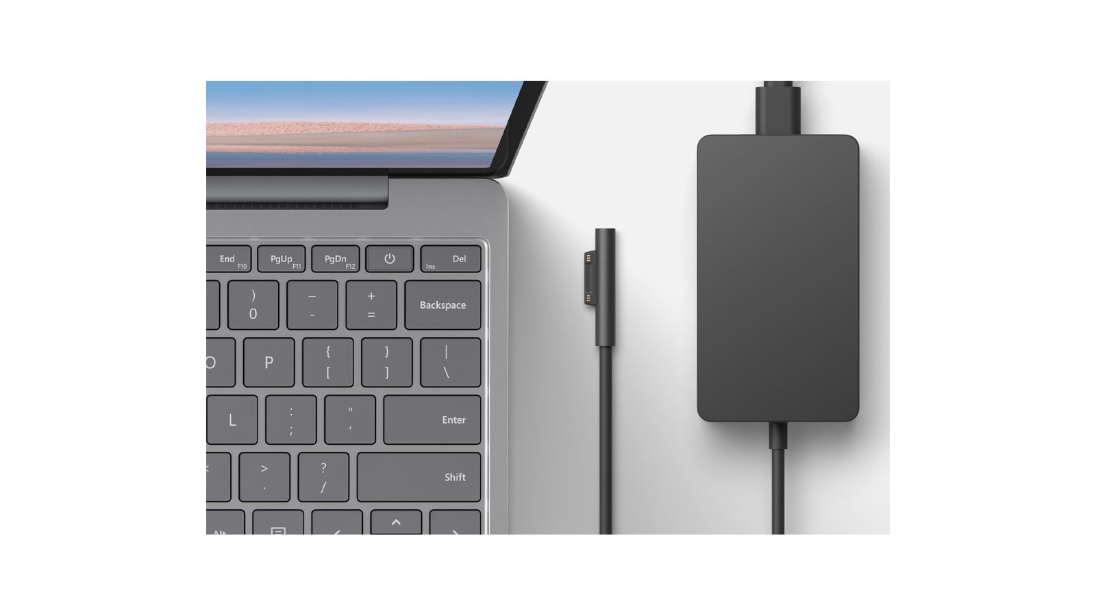 Ein aufgeklappter Surface Laptop Go und ein Ladekabel: Ansicht von oben