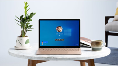 Person seated near a window working with Surface Laptop 4 for Business.