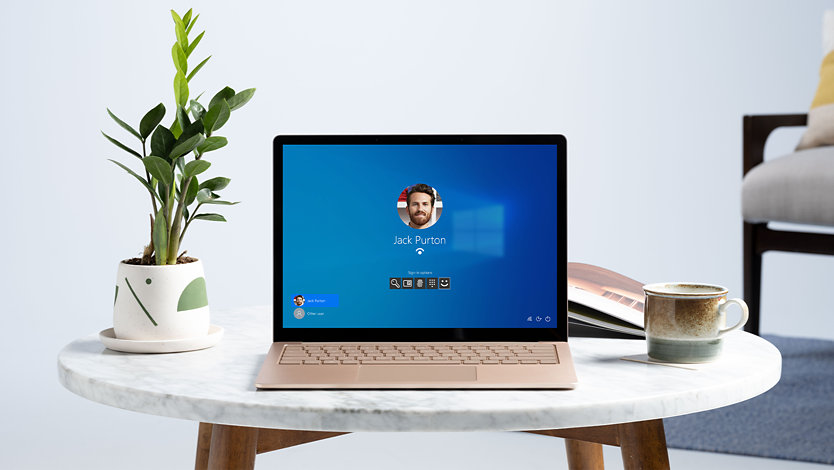 A Surface device on a table with Windows 10 Pro on screen..