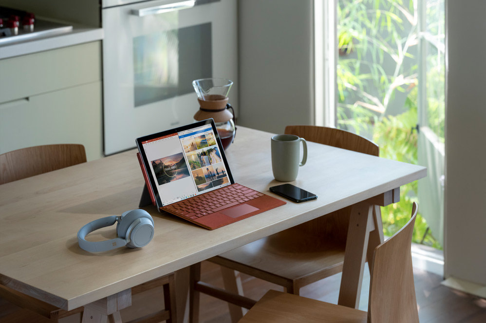 Surface Pro 7 sur une table à côté d’un casque Surface Headphones 2 et d’un téléphone portable