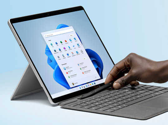 A hand placing Slim Pen 2 on Surface Pro Signature Keyboard.