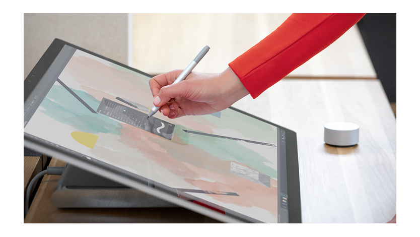  A person using a Surface Studio 2 with a Surface Pen and Surface Dial.