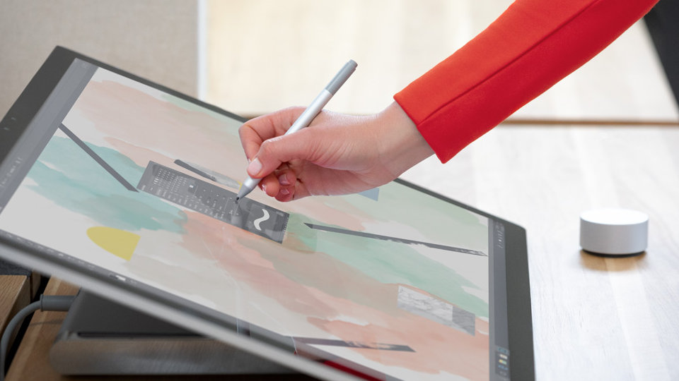 A person sketching on Surface Studio 2 with a Surface Pen and Surface Dial.