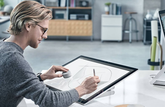 Un homme utilise un Surface Dial sur l’écran du Surface Studio 2.