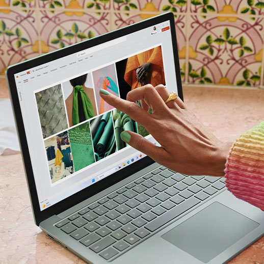 A close-up view of a person interacting with the touchscreen on their Surface Laptop 5.