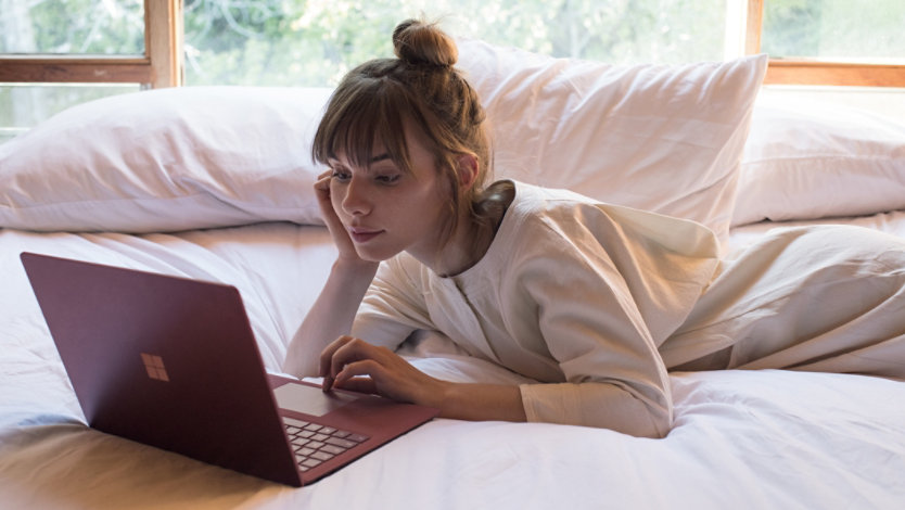 Eine junge Frau mit einem Surface Laptop 5. 