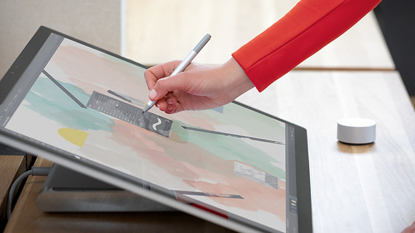 A person uses Surface Dial and Surface Pen with Surface Studio 2.