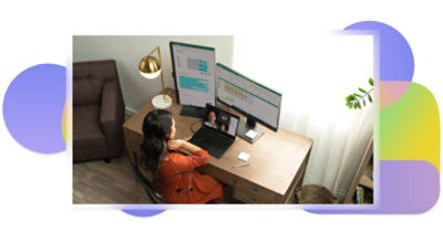 A person on a Teams call at their desk while their additional screens display data in Excel.