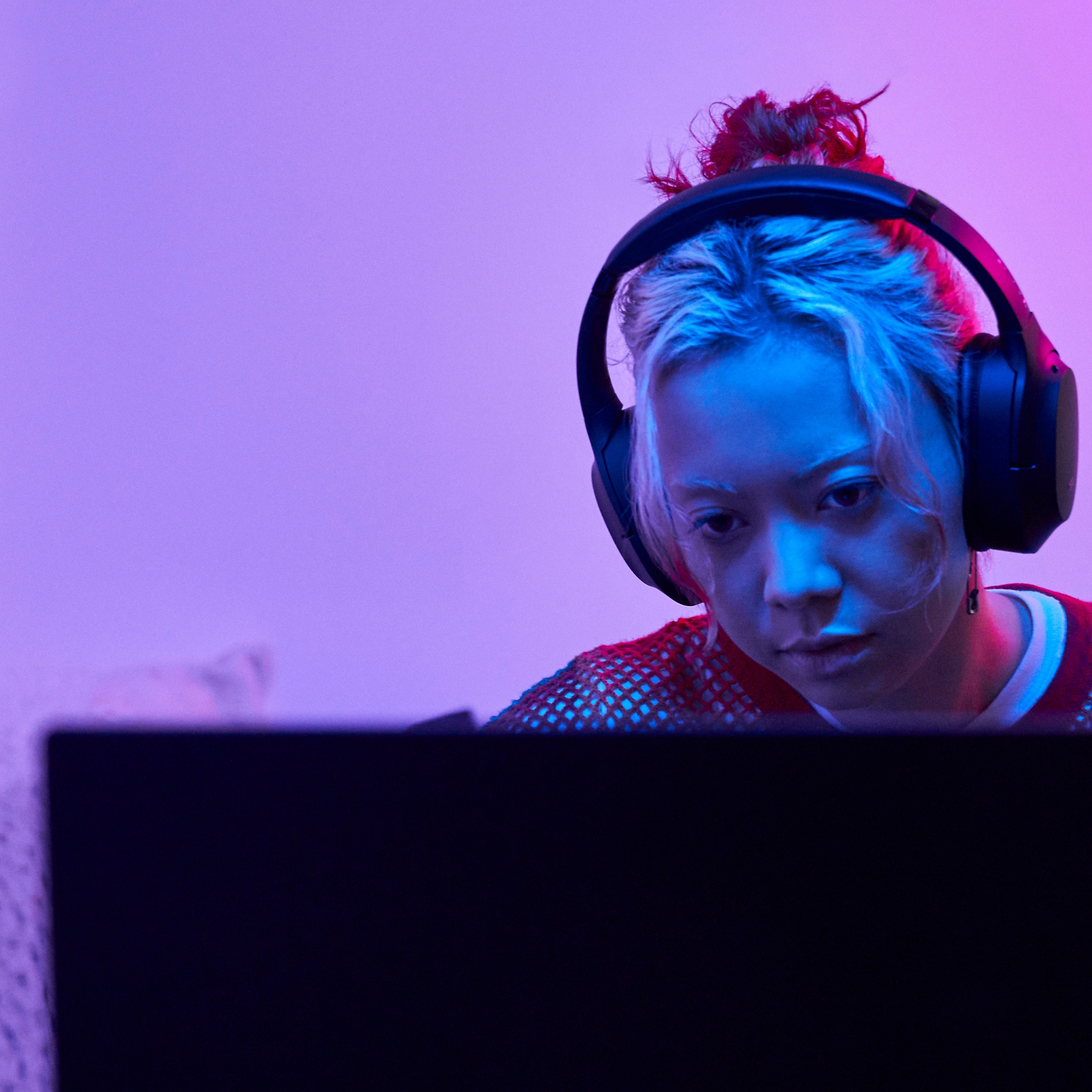 Kulaklık takan bir kadın bilgisayar karşısında oturuyor