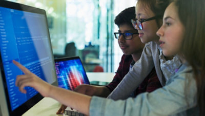 Students programming at computer in computer lab classroom.
