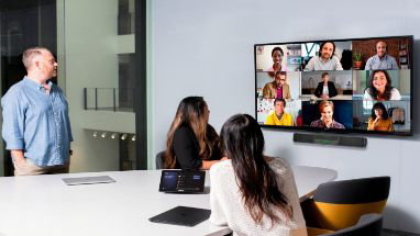 Drei Personen in einem Besprechungsraum in einem Teams-Videoanruf mit 9 weiteren Teilnehmenden.