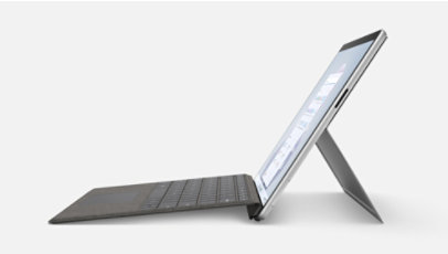 Surface Pro 9, vanaf de zijkant afgebeeld met een gekoppelde type cover en de standaard uitgeklapt.