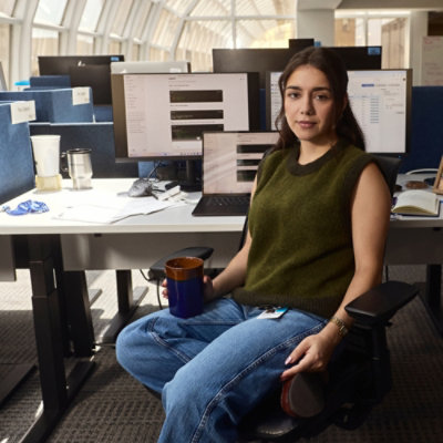 A person sitting in a chair holding a cup.