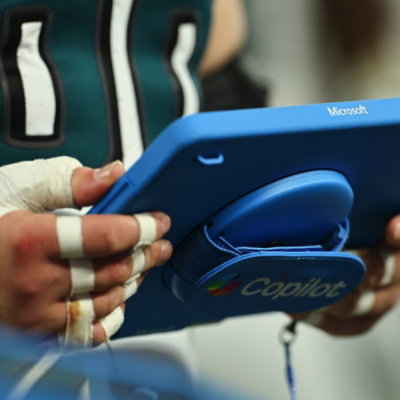 Hands using a handheld device to capture player performance data.