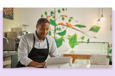 Работник в фартуке с планшетным устройством.