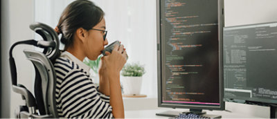 A woman sitting in a chair drinking from a cup.