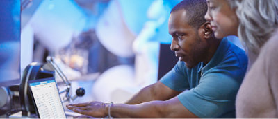 A man and woman using a laptop.