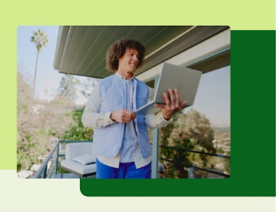 A person standing in the patio and using his laptop
