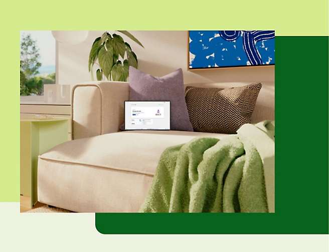 Et billede, der viser en sofa med puder og et tæppe i et rum