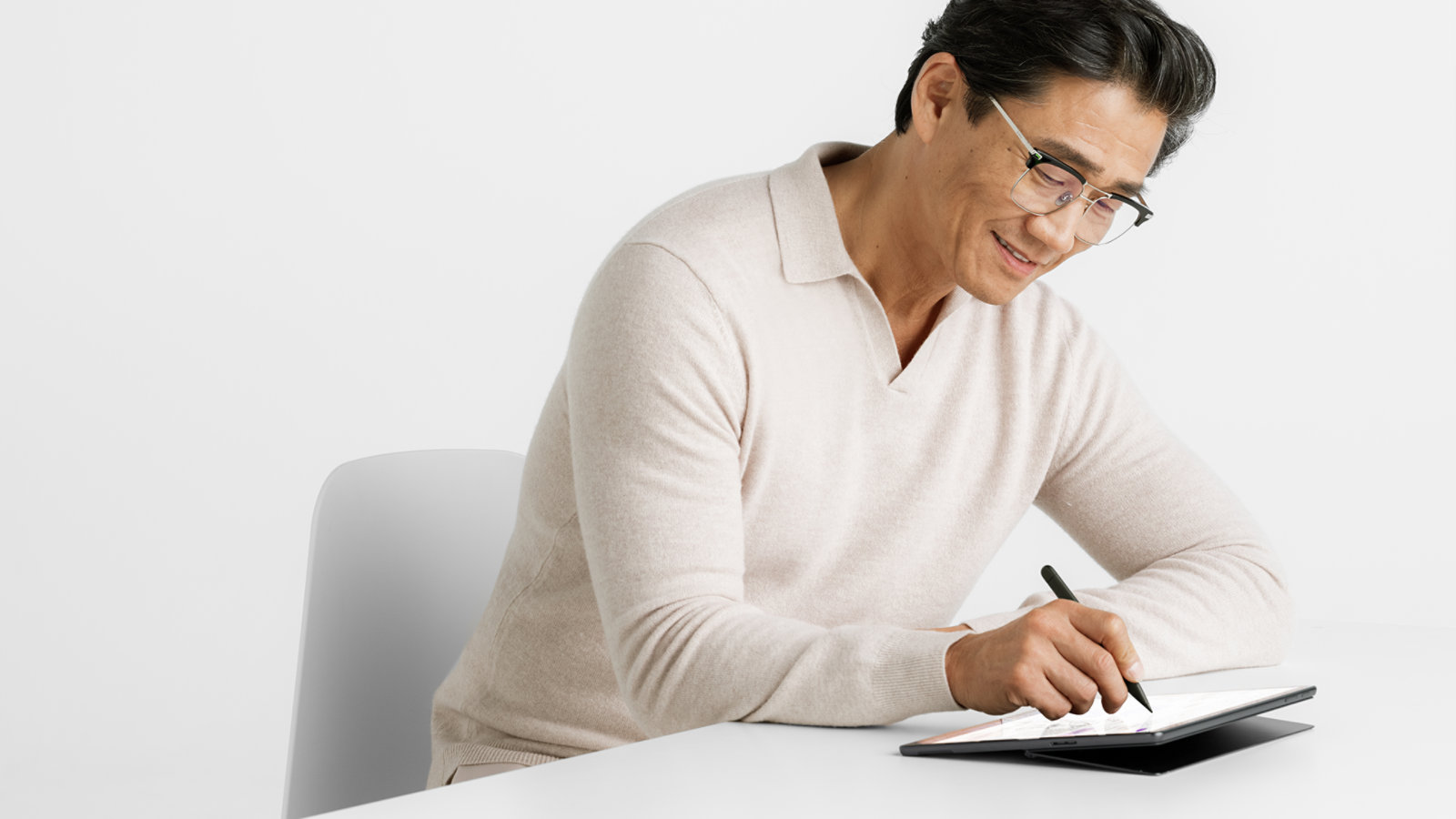 A person uses a Surface Slim Pen for Business to write on the touchscreen of a Surface Pro 10 for Business.