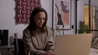 A lady looking at the laptop.