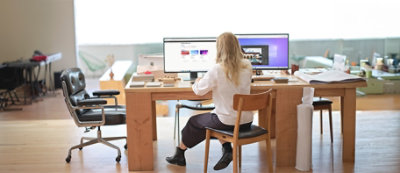 A person sitting at a desk looking at a computer