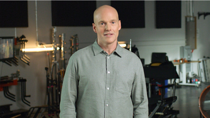 Man smiling and standing amongst film production equipment