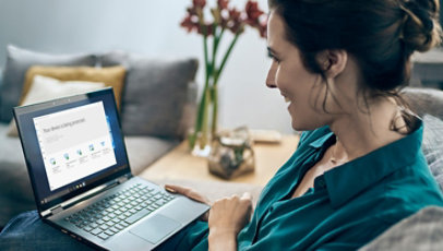 Une femme assise à son bureau avec un nouvel ordinateur Windows 10.