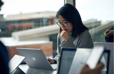 O persoană stând într-un birou și utilizând un laptop.