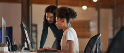 A man and woman looking at a computer.