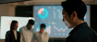 A blurry image of a man looking at a screen.