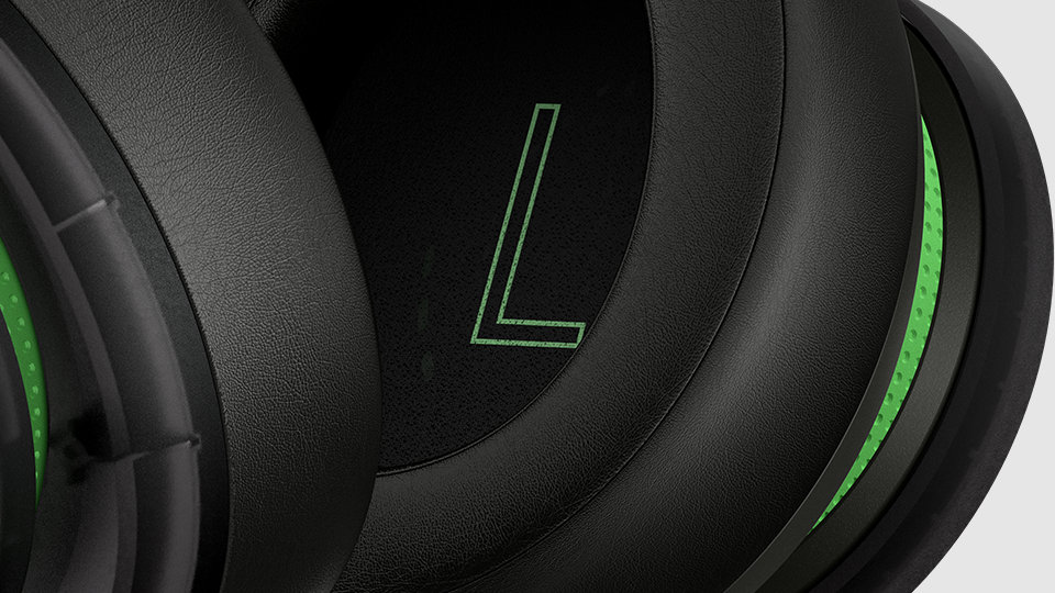Zbliżenie głośnika lewego nausznika stereofonicznego zestawu słuchawkowego do konsoli Xbox w specjalnej wersji z okazji 20-lecia