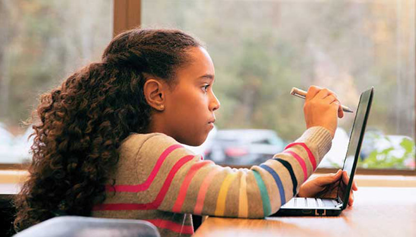 Ein Schüler schreibt mit einem Stift auf dem Laptop-Bildschirm