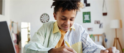 一名男孩在书上写字。